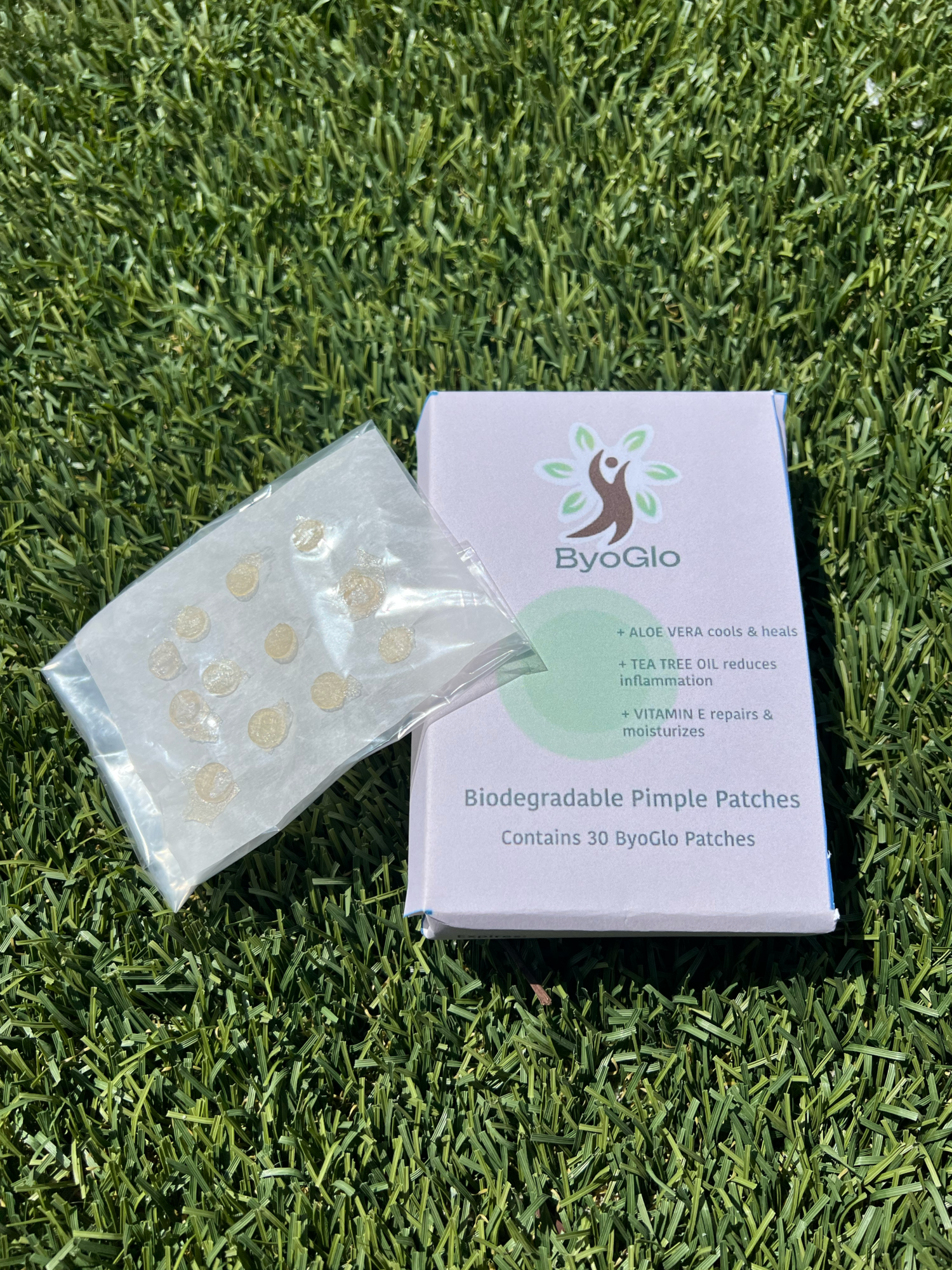 photo of ByoGlo Aloe Pimple Patches, packaging: green dot on pink box, background: green grass